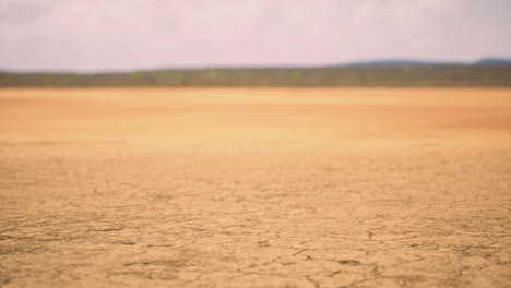 dry cracked earth under a cloudy sky in a remote landscape during daytime