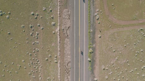 An-aerial-nose-down-shot-of-a-group-of-motorcycles-riding-down-a-backroad-in-Arizona