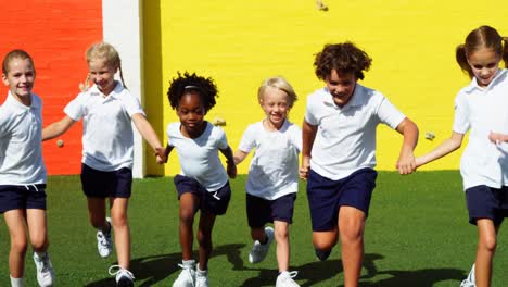 Niños-De-La-Escuela-Tomados-De-La-Mano-Y-Corriendo-En-El-Campus