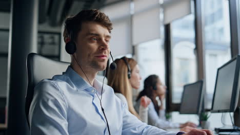 call center operator talking headset in data office. friendly man representative