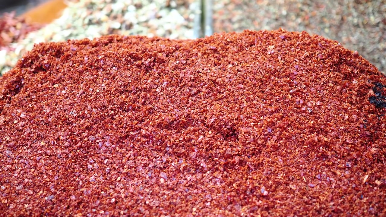 Gros plan de flocons de piment rouge vif dans un marché aux épices