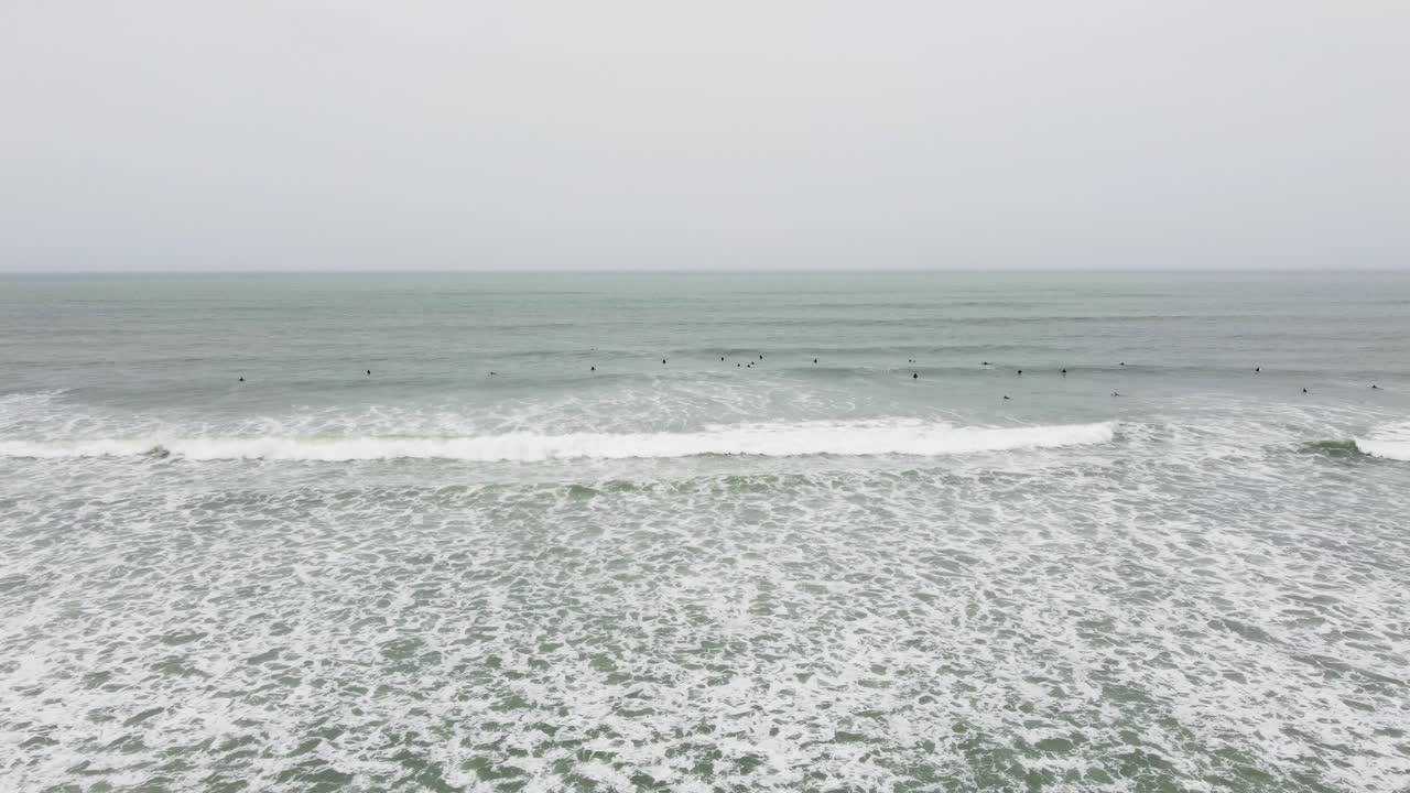바다로 패들링하는 서퍼들의 드론 영상