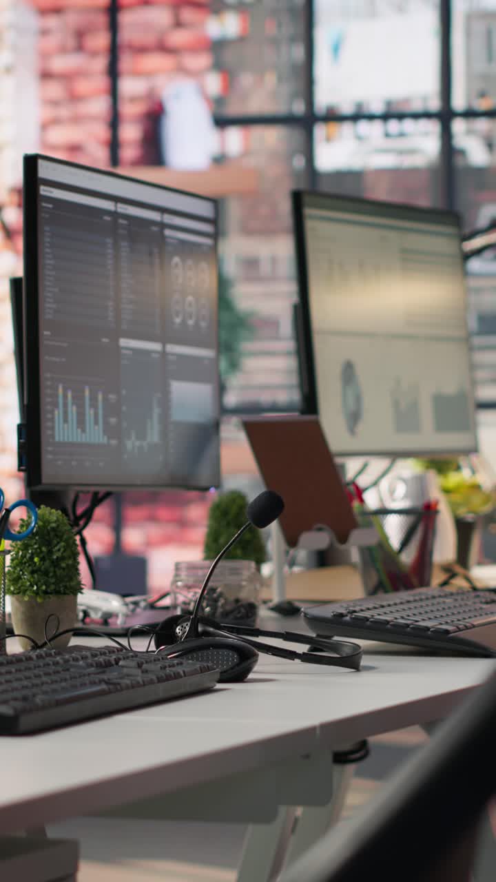 Vertical video Computer monitors in empty office displaying analytics dashboards