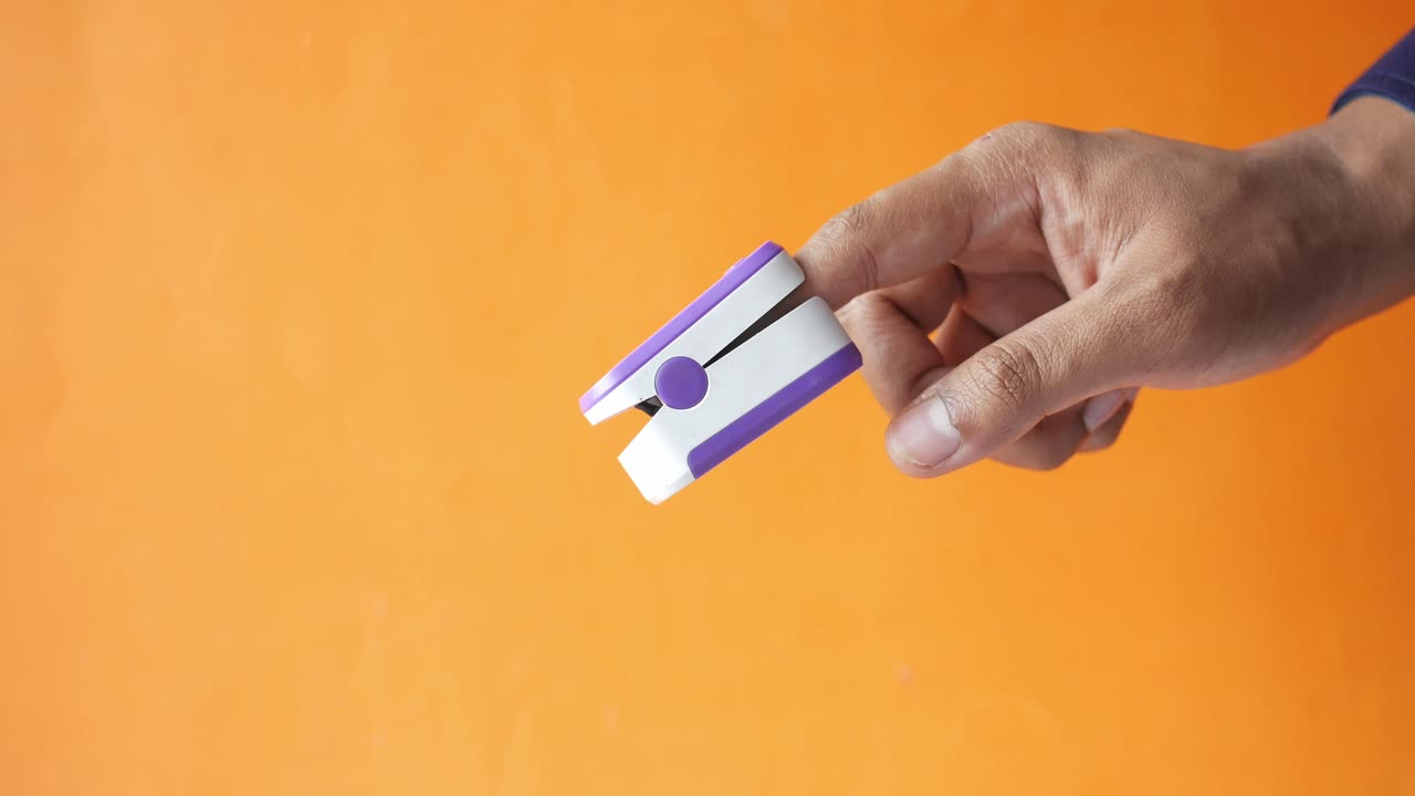 mano con un oxímetro de pulso