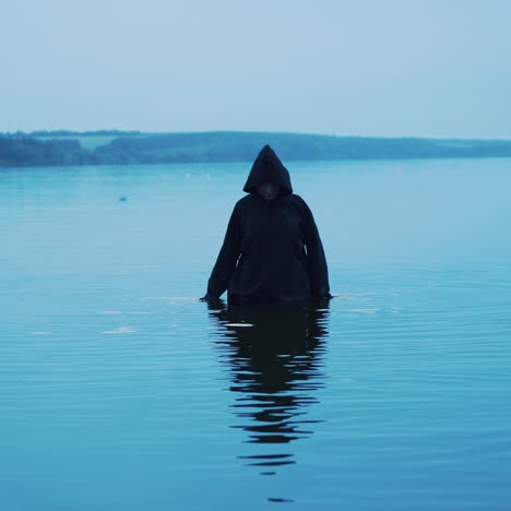 scary figure in black mantle. halloween costume