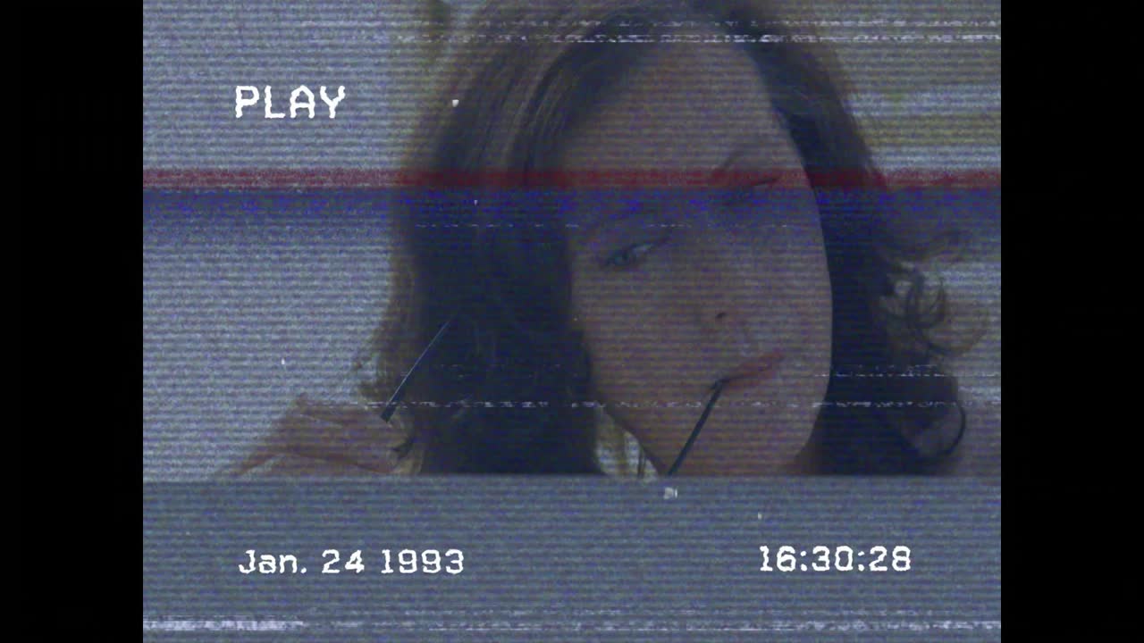 Woman holding glasses to mouth as archival playback starting, reflecting with timestamp overlaying