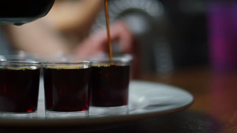 the last shot of jägermeister on a tray of shots being filled in slow motion