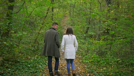 couple walking through autumn forest