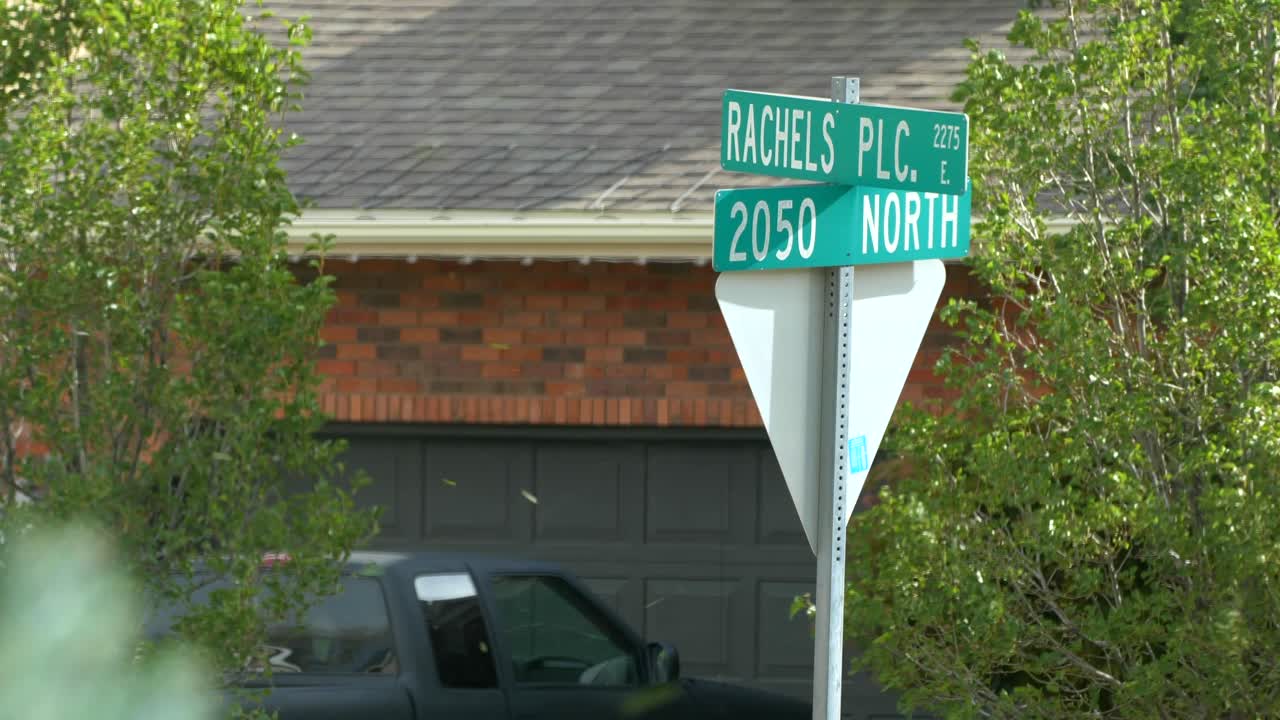 Fierce 70-80 mile per hour winds hit a road sign hard causing it to sway and wiggle back and forth.