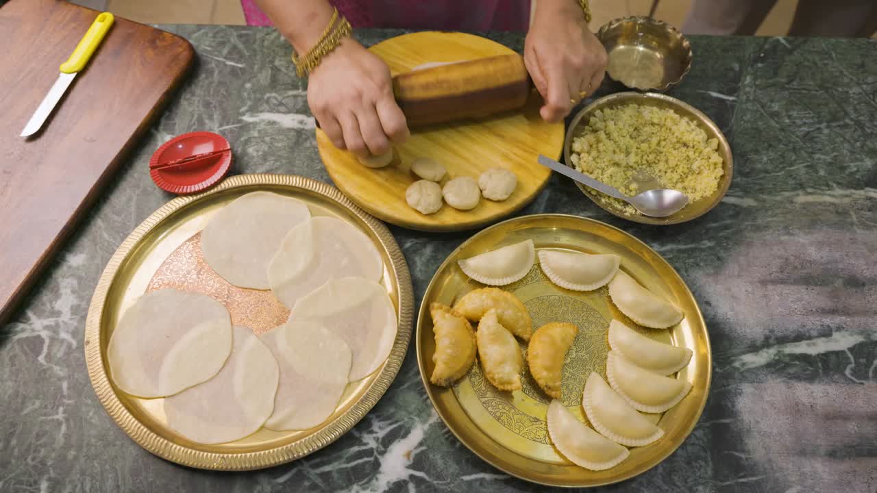 una mujer india preparando gujia, un bocadillo popular indio especialmente hecho en el festival de colores de holi