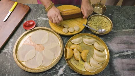 an indian woman preparing gujia, an indian popular snack especially made in holi festival of colors