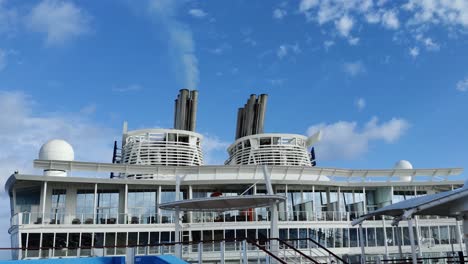 huge cruise ship chimney or smoke funnel with a smoke billowing out in the skies video background | one smokestack out of two on cruise ship with smoke billowing out into the sky-2