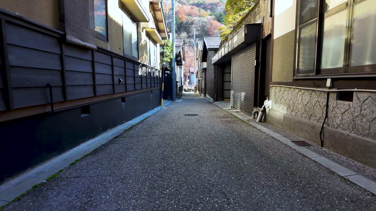 First person view walking on narrow paved street between traditional Japanese houses in Narai juku, on sunny morning