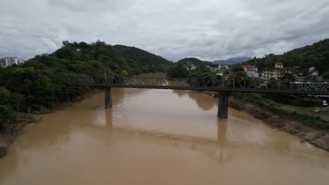 aerial-view-of-the-Iron-Bridge-,-crossing-the-Itajaí-Açu-river,-in-the-center-of-the-city-of-Blumenau,-Santa-Catarina,-Brazil