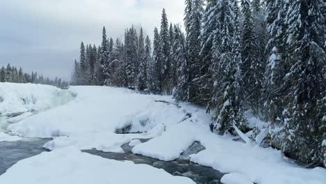 Stream-flowing-through-snowy-forest-4k