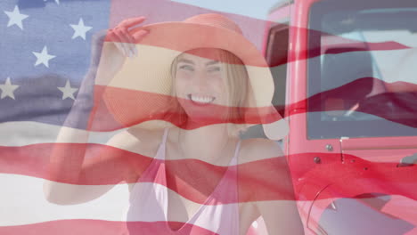 animation of flag of usa over caucasian woman by car on beach