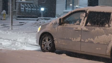 a front wheel drive van struggling to move and spinning its tires to try and get traction with the road after a massive blizzard brought lots of snow to the city