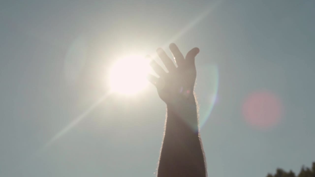 la mano se extiende hacia el sol