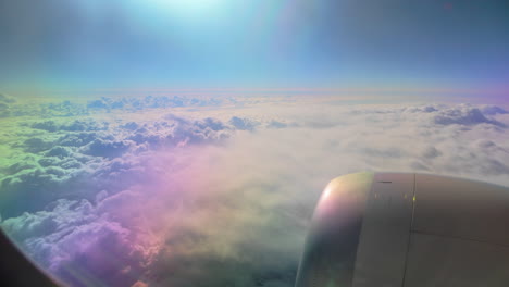 a colorful sky and cloudscape seen from a plane, featuring the aircraft engine and bright sunlight