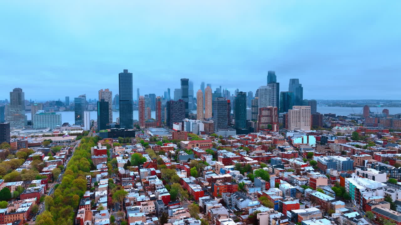 Jersey City, USA, 15 aprile 2026: Quartiere residenziale e skyline del centro di Jersey City. Ampia veduta aerea di isolati residenziali di Jersey City, alberi, torri e il fiume Hudson sotto un cielo nuvoloso