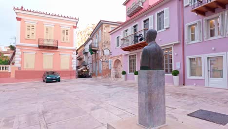 colorful buildings and a bust in a greek town square