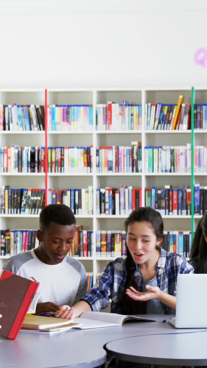 Composizione digitale di diversi alfabeti che fluttuano su un gruppo di studenti che studiano in biblioteca.