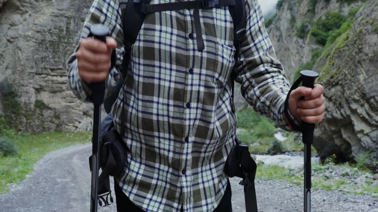 산악 협곡 에서 하이킹 스 을 들고 있는 하이커