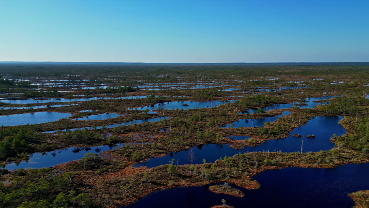 Flat marsh wetland islands in a wide landscape - aerial parallax