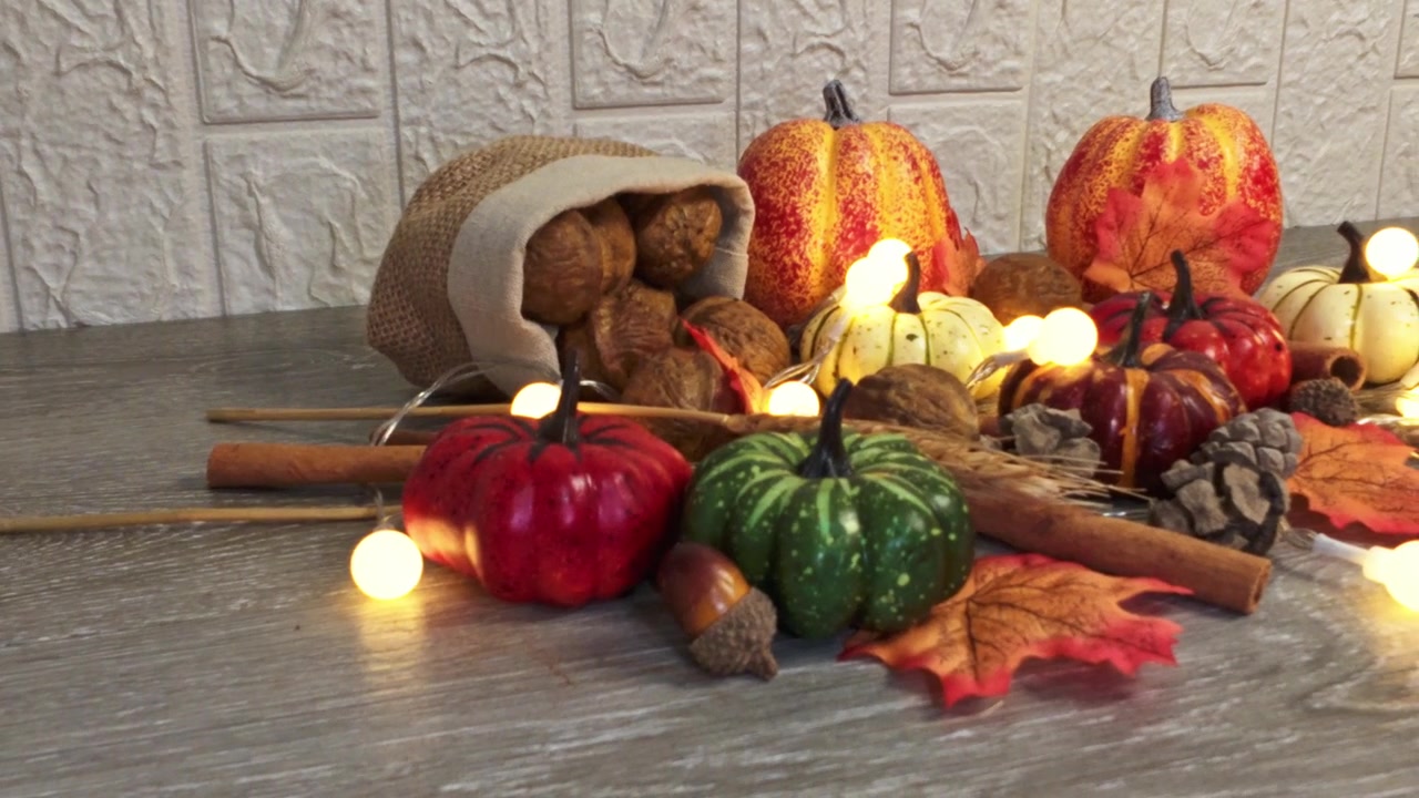 Bodegón festivo otoñal con calabazas y luces de hadas