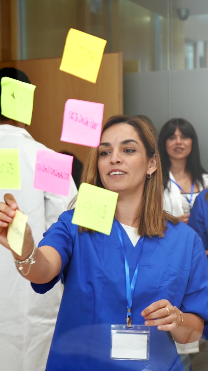 Medical Team Collaborating with Sticky Notes on Glass Wall