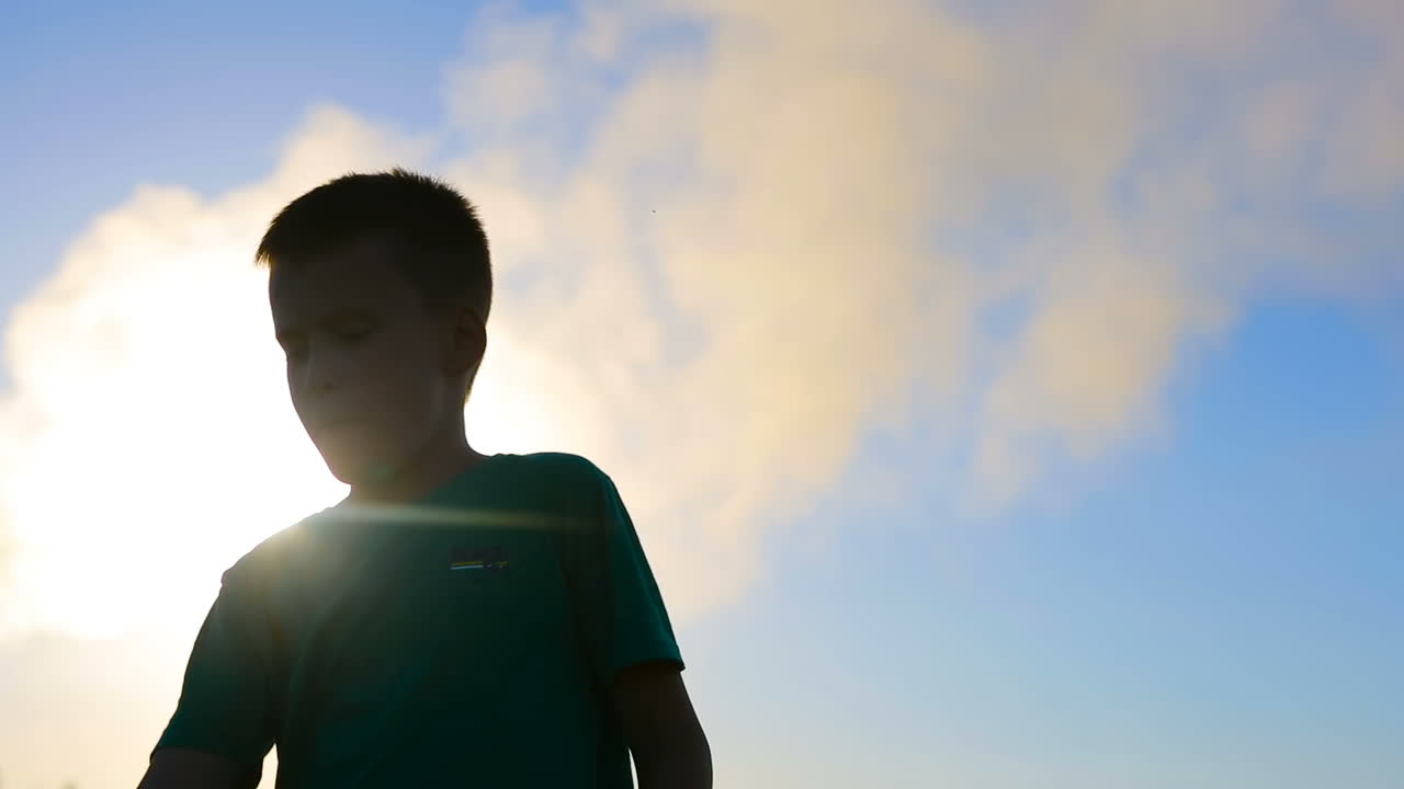 Kid Playing With Paper Airplane. Happy kid playing with paper airplane in the sunset near air pollution