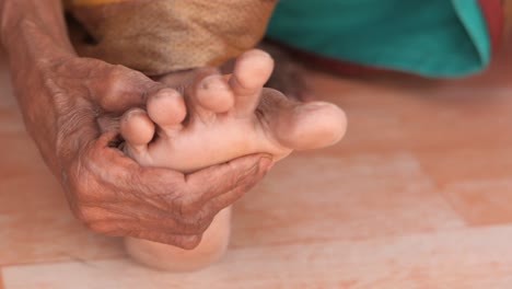 elderly woman massaging her foot