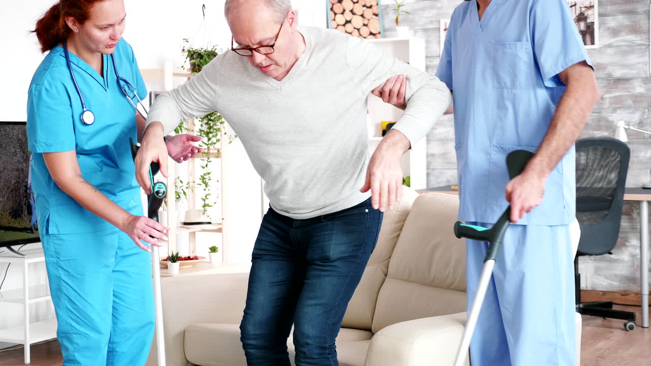 Retired old man in nursing home getting help from professional social workers