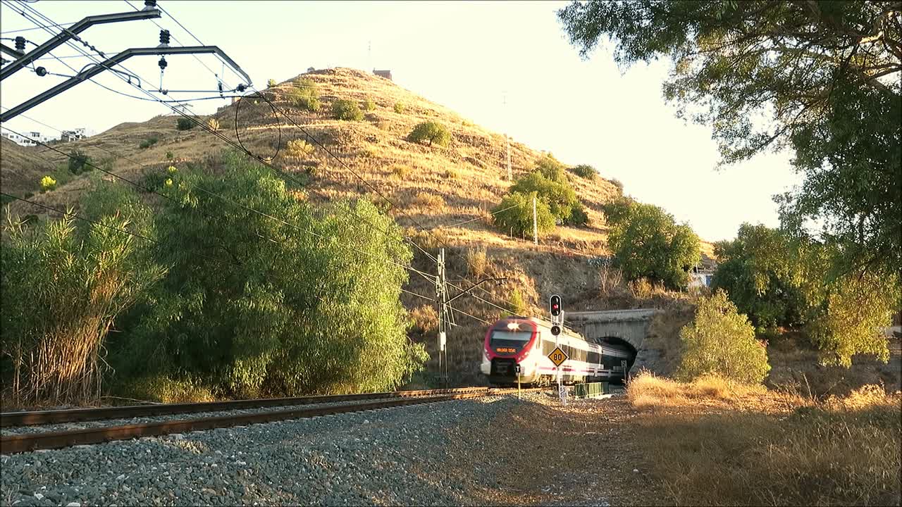 Alora, Spain - September 14, 2018: Alora to Malaga commuter train emerging from tunnel on electric track near Alora Andalusia