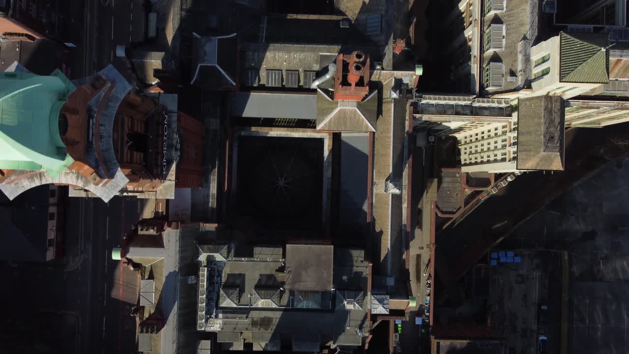 Aerial drone flight over the Kimpton Hotel on Oxford Road in Manchester City Centre giving a birdseye view of the Refuge Building rootops below
