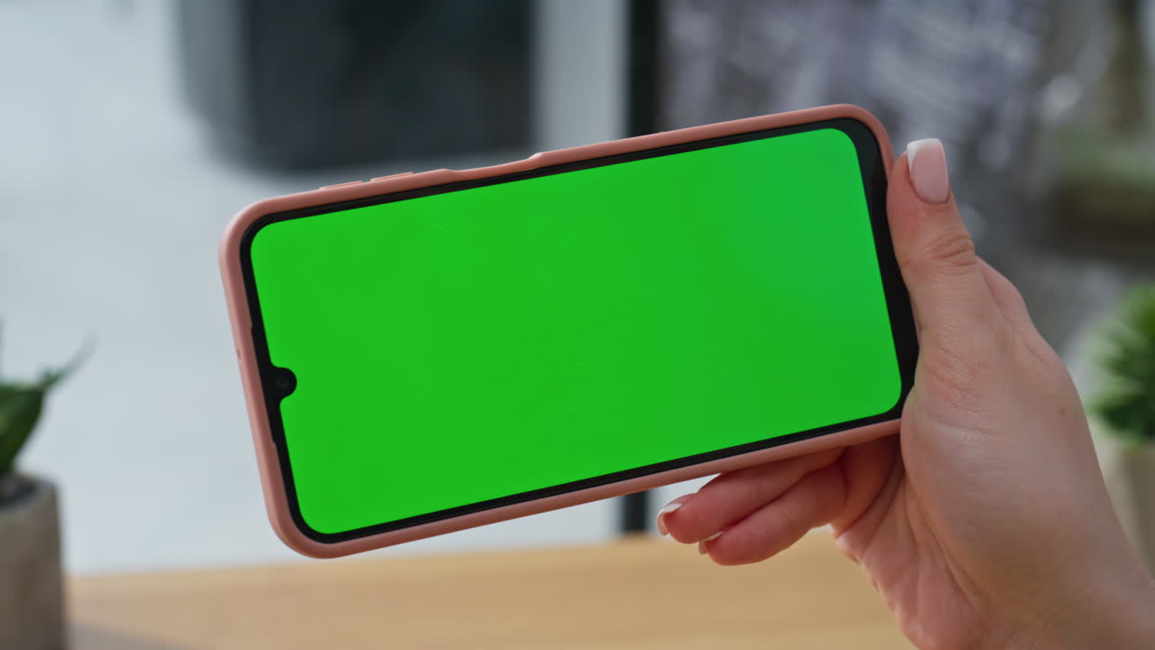 Businesswoman fingers using chromakey smartphone surfing on workplace closeup