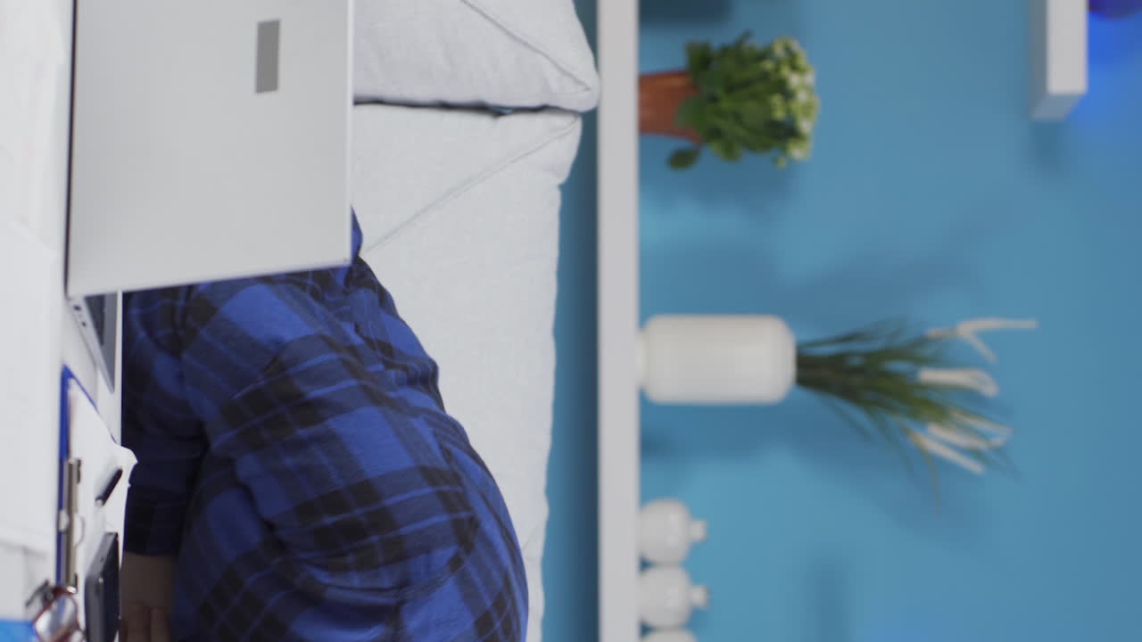 노트북에서 일하는 홈 오피스 직원의 수직 비디오, 그것을 사용하는 재미.