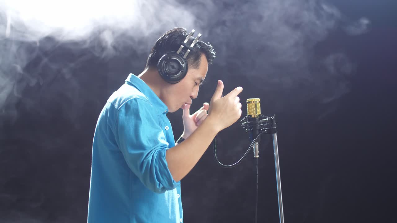 녹음 스튜디오 에서 마이크 로 노래 하는 남자