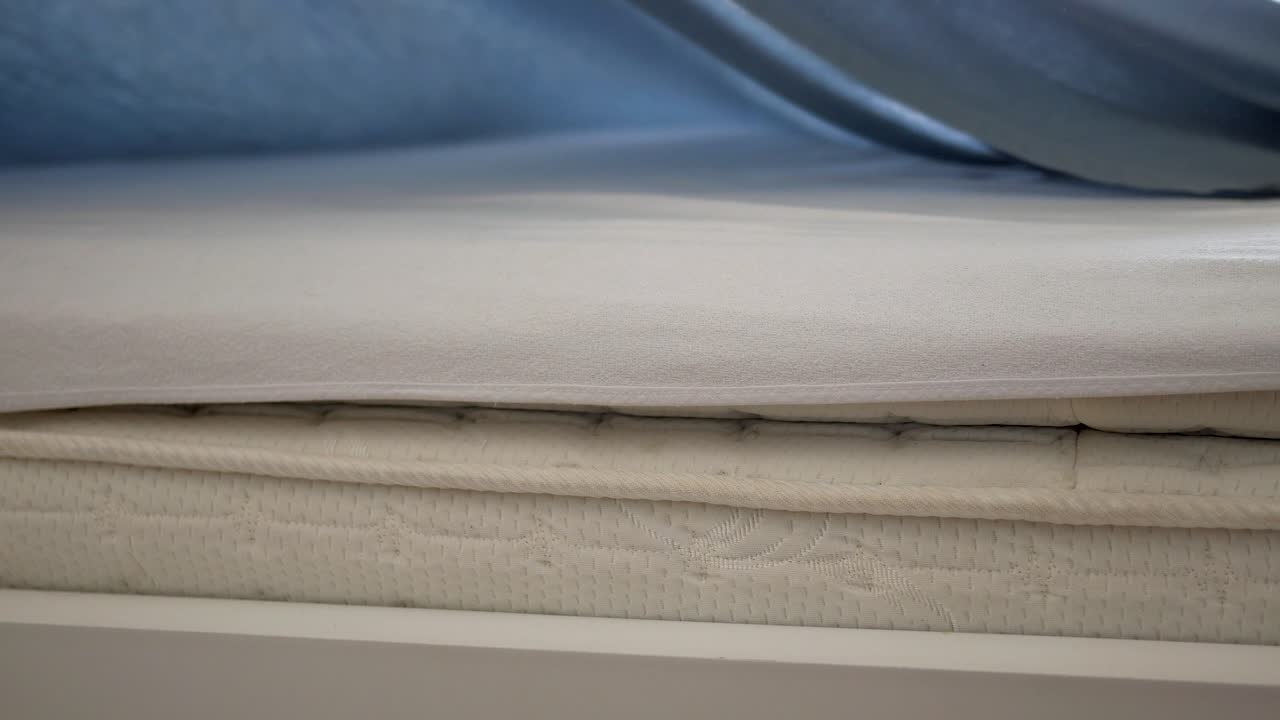 un colchón blanco con sábanas grises