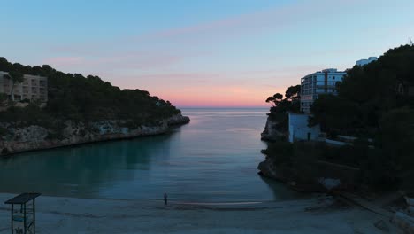 aerial view of calm bay waters with pink sunset clouds on horizon in palma de mallorca