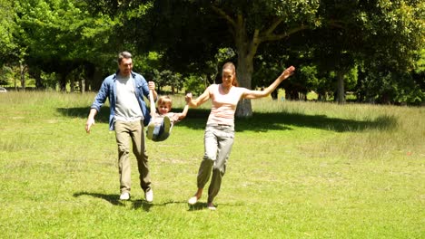 Little-boy-and-parents-running-towards-camera-in-the-park-