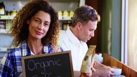 woman holding a board that reads organic coffee