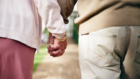 elderly couple holding hands