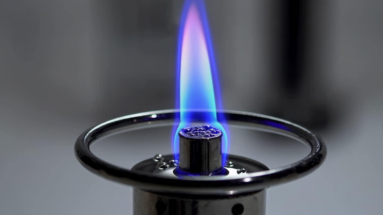 Close-up of a portable gas burner with a blue flame