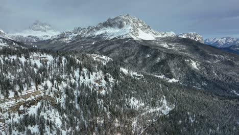 wide drone aerial view of mountains with snow in winter