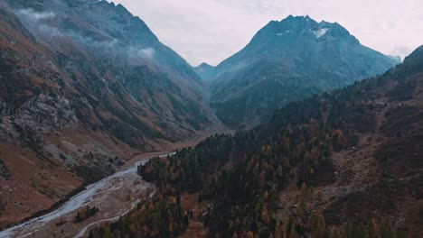 Fliegen-Auf-Dem-Malojapass-In-Der-Schweiz,-Dem-Gebirgsfluss-Folgend-In-Richtung-Des-Großen-Berges-Im-Herbst-In-Einer-Stimmungsvollen-Umgebung