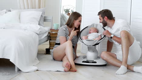 retrato de cerca de unos padres felices viendo a su bebé durmiendo en una cama en casa