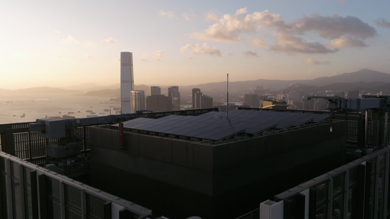 primer plano levantando un dron del hotel rosewood revelando tsim sha tsui y west kowloon durante la puesta de sol