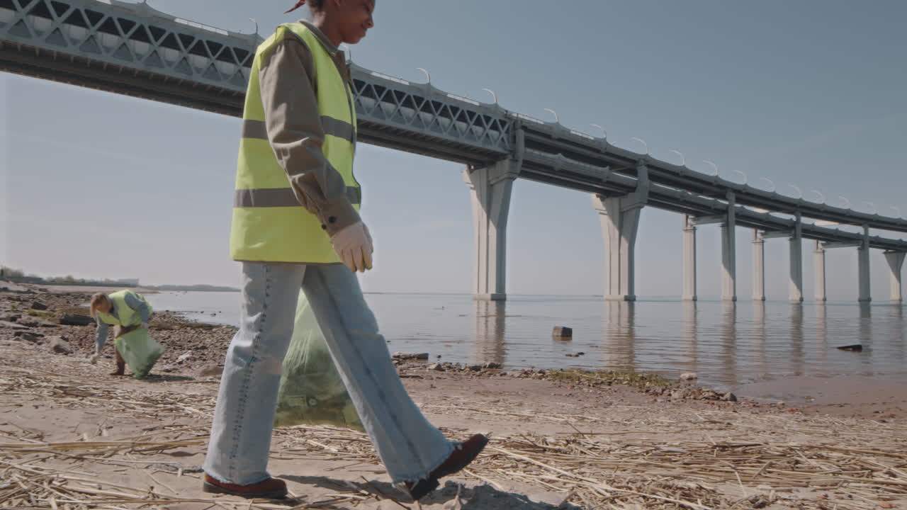 Female Environmental Volunteer Cleaning Up Shore