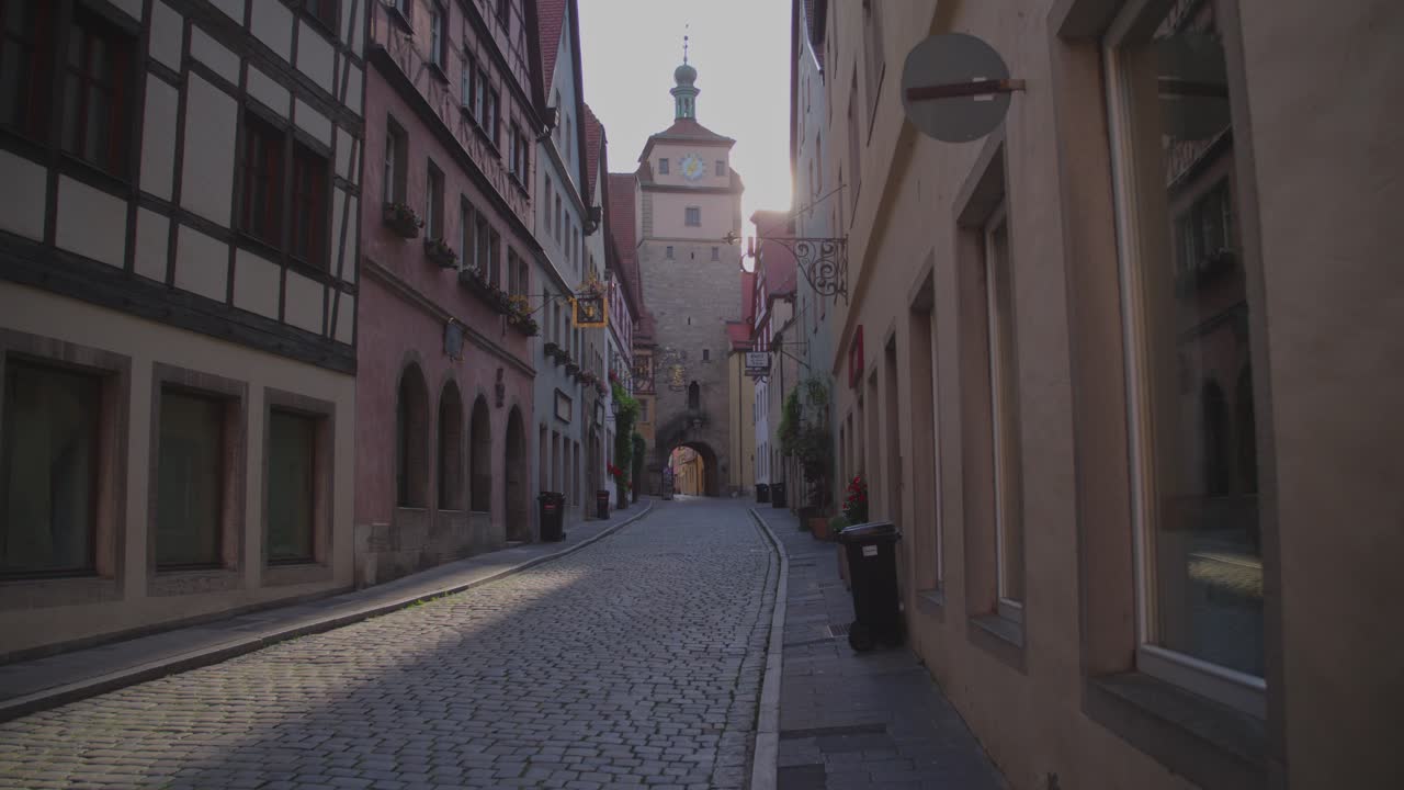 A peaceful cobblestone street lined with historic medieval buildings in the morning light.
